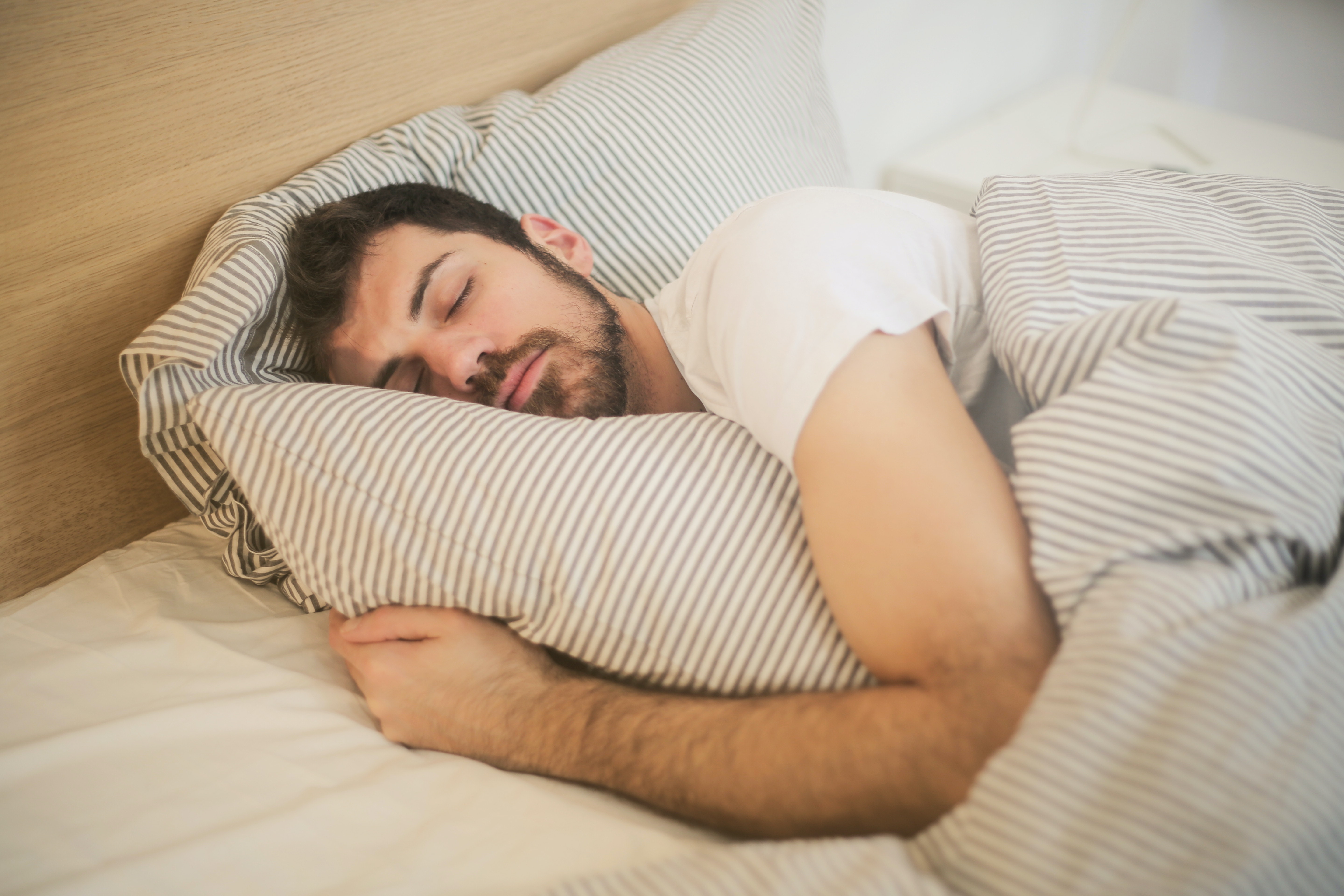 A man sleeps restfully in bed